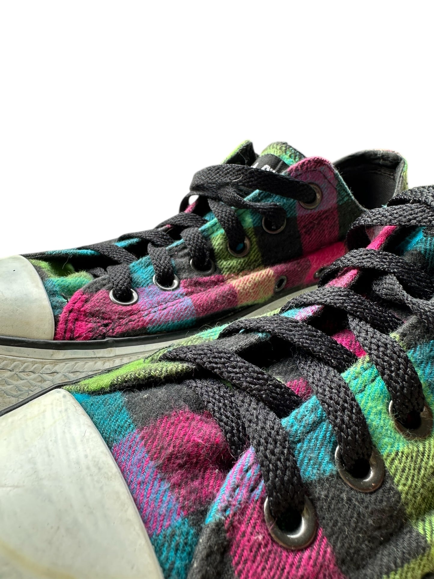 Dettaglio dei lacci neri di un paio di converse all star basse a fantasia di quadretti colorati